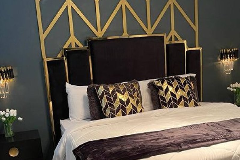 Master suite with king bed and gold chevron accent wall