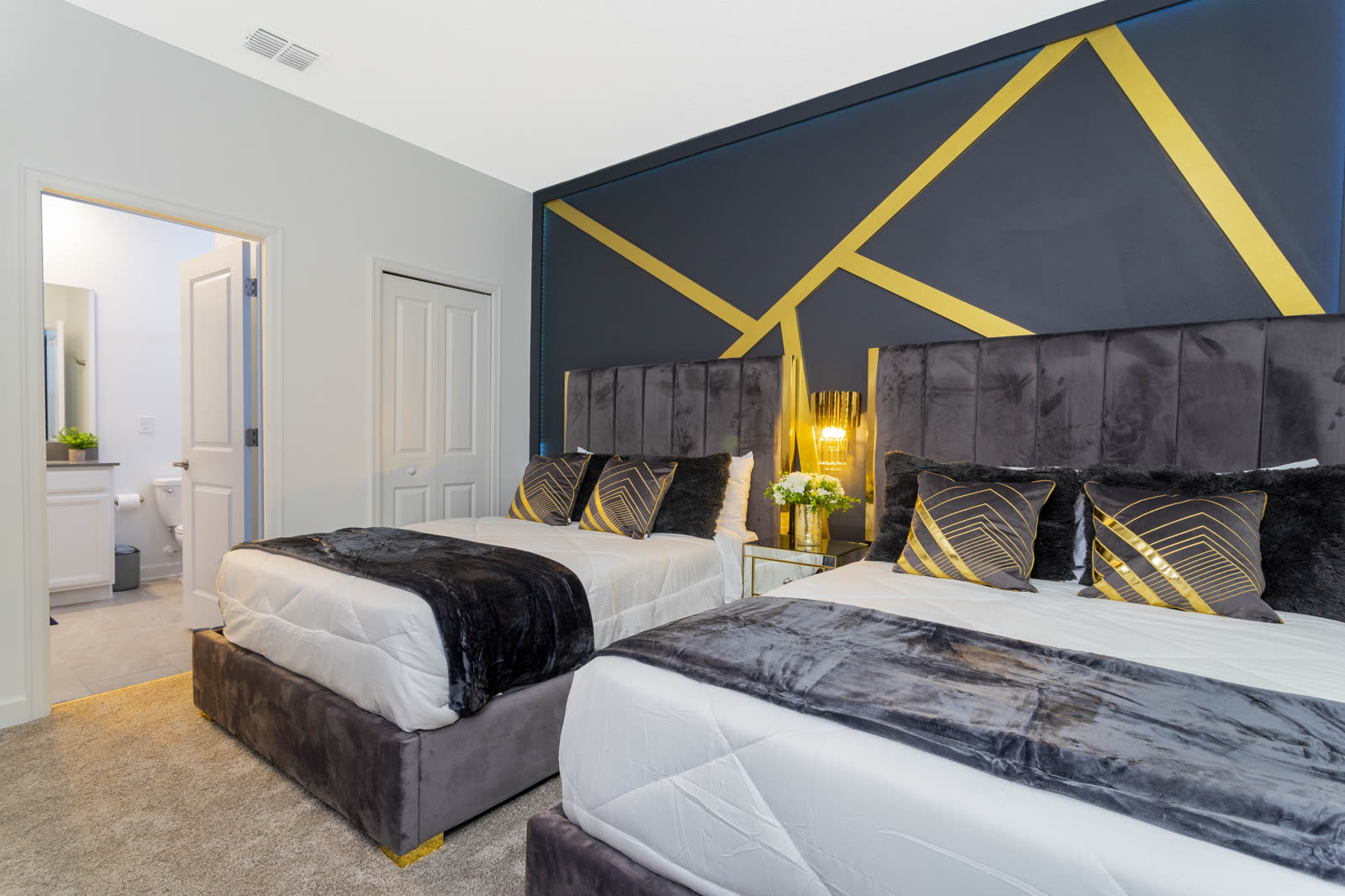 Navy and gold bedroom with two queen beds at The Incredibles villa